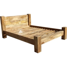 Duże łóżko z drewna na nogach z bali drewnianych 