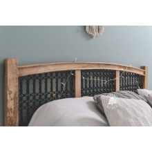 Łóżko z drewna z ozdobnymi panelami z kutego metalu